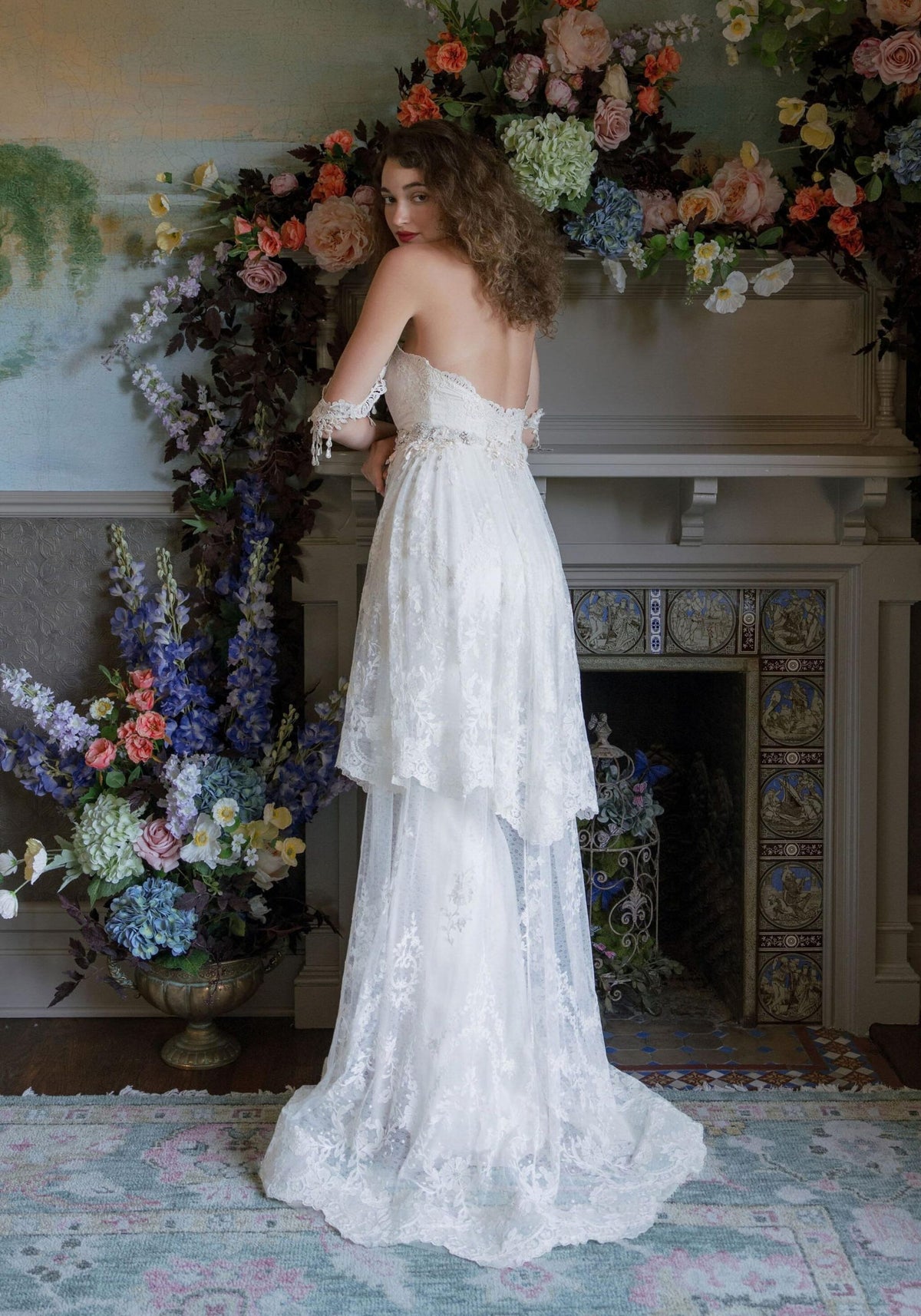 Back view of the Amourette tiered lace wedding dress with flowing lace train