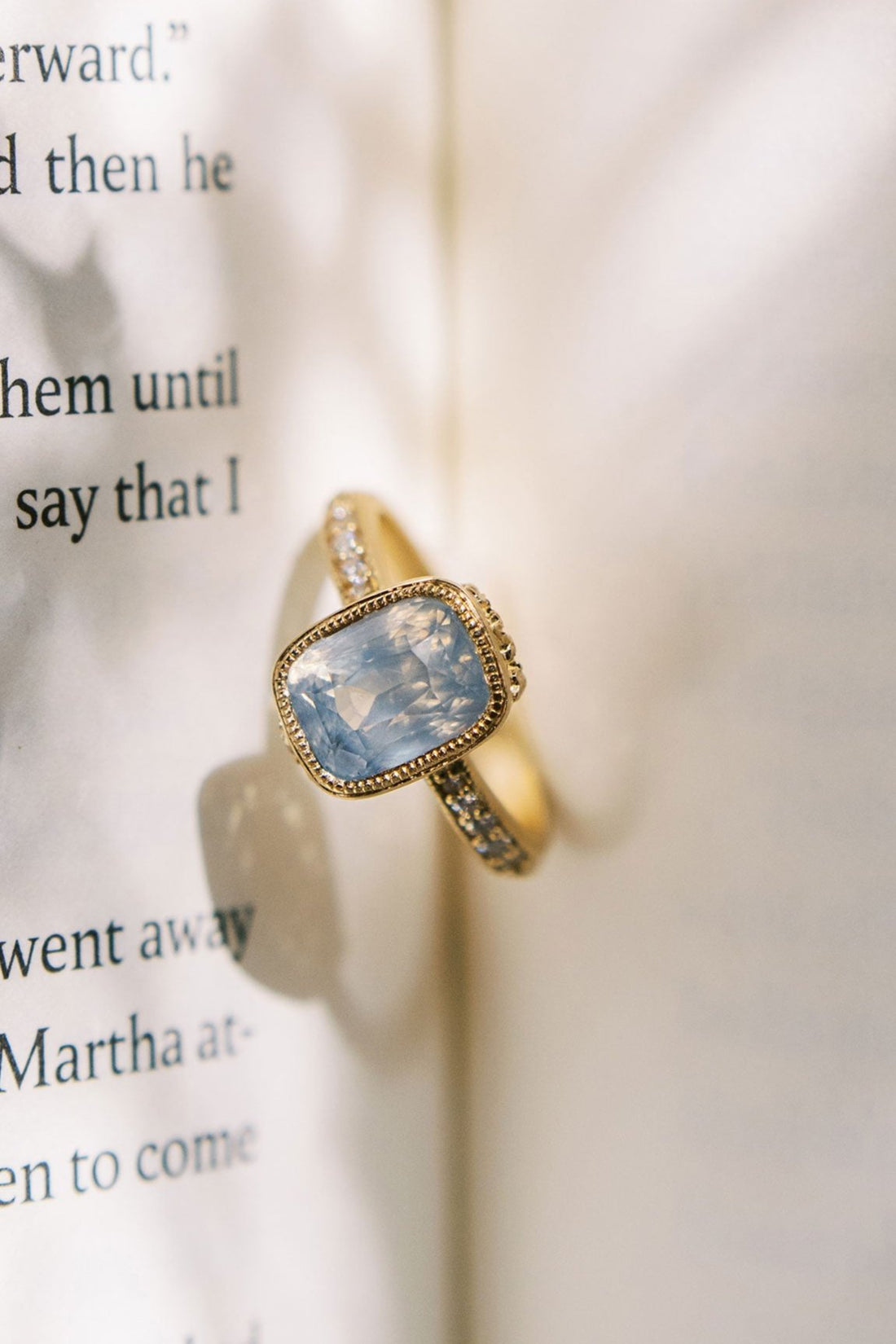 Aurelie Natural Sapphire and Diamond Engagement and Wedding Ring in the center of a book.