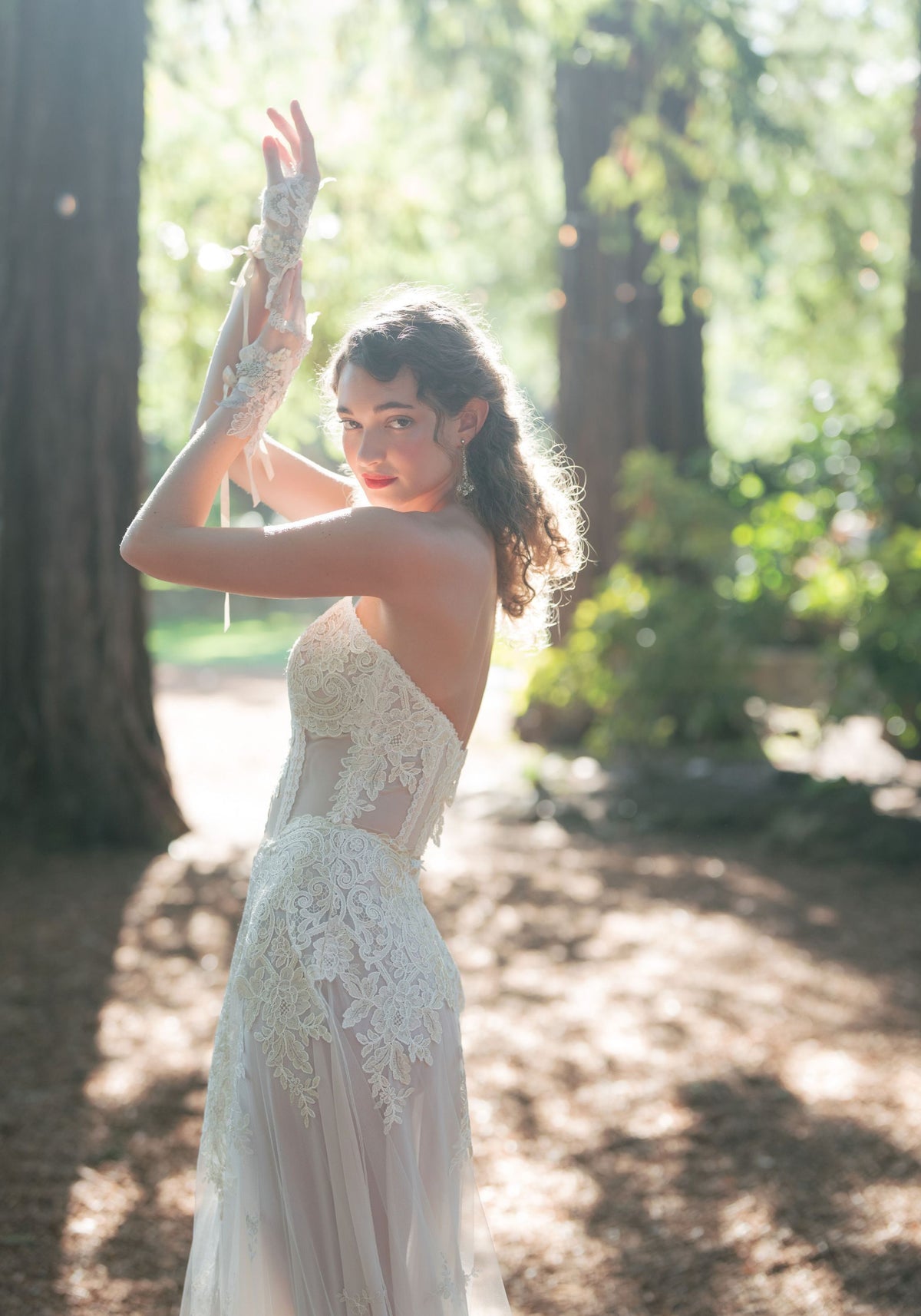 Side view of the Narcisse strapless lace wedding dress with sheer lace bodice insets in sunlight