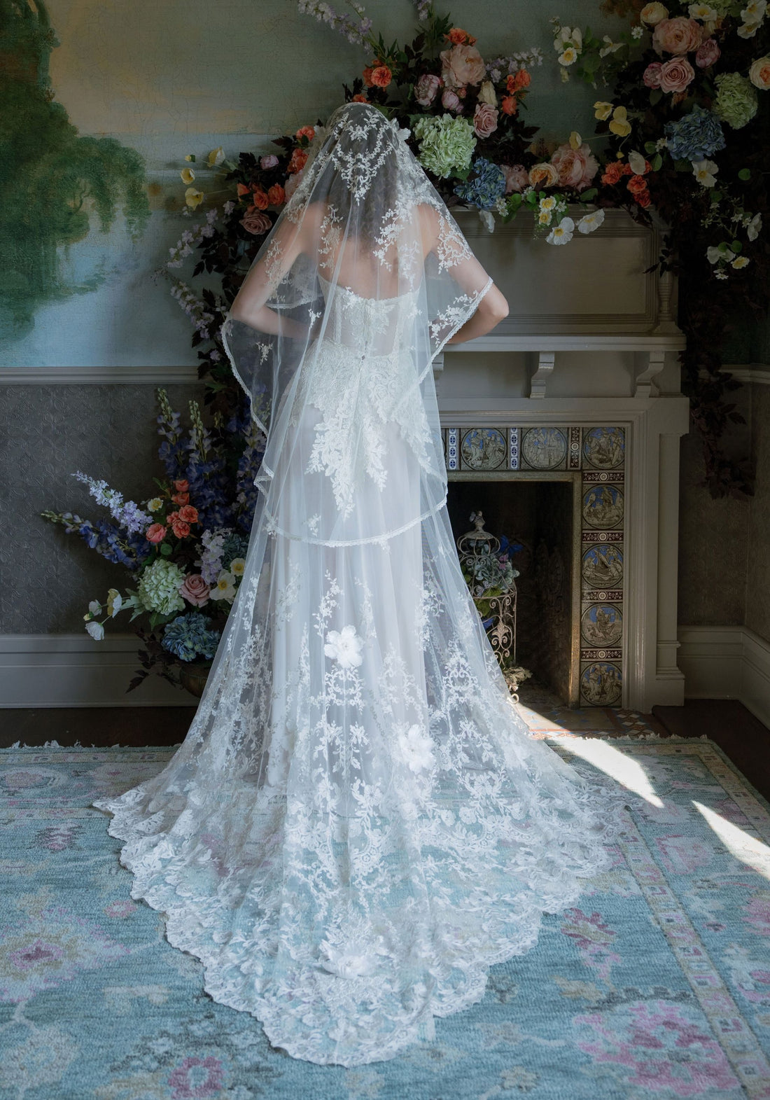 Back of the Narcisse wedding dress with scalloped lace train beneath a long lace-edged veil