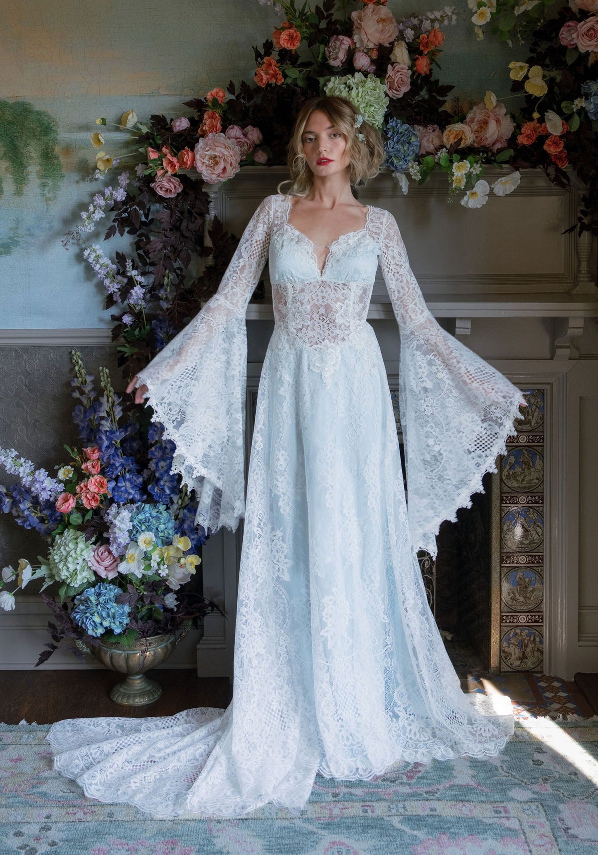 Serenade ivory lace wedding dress over blue silk with dramatic bell sleeves and flowing train by Claire Pettibone