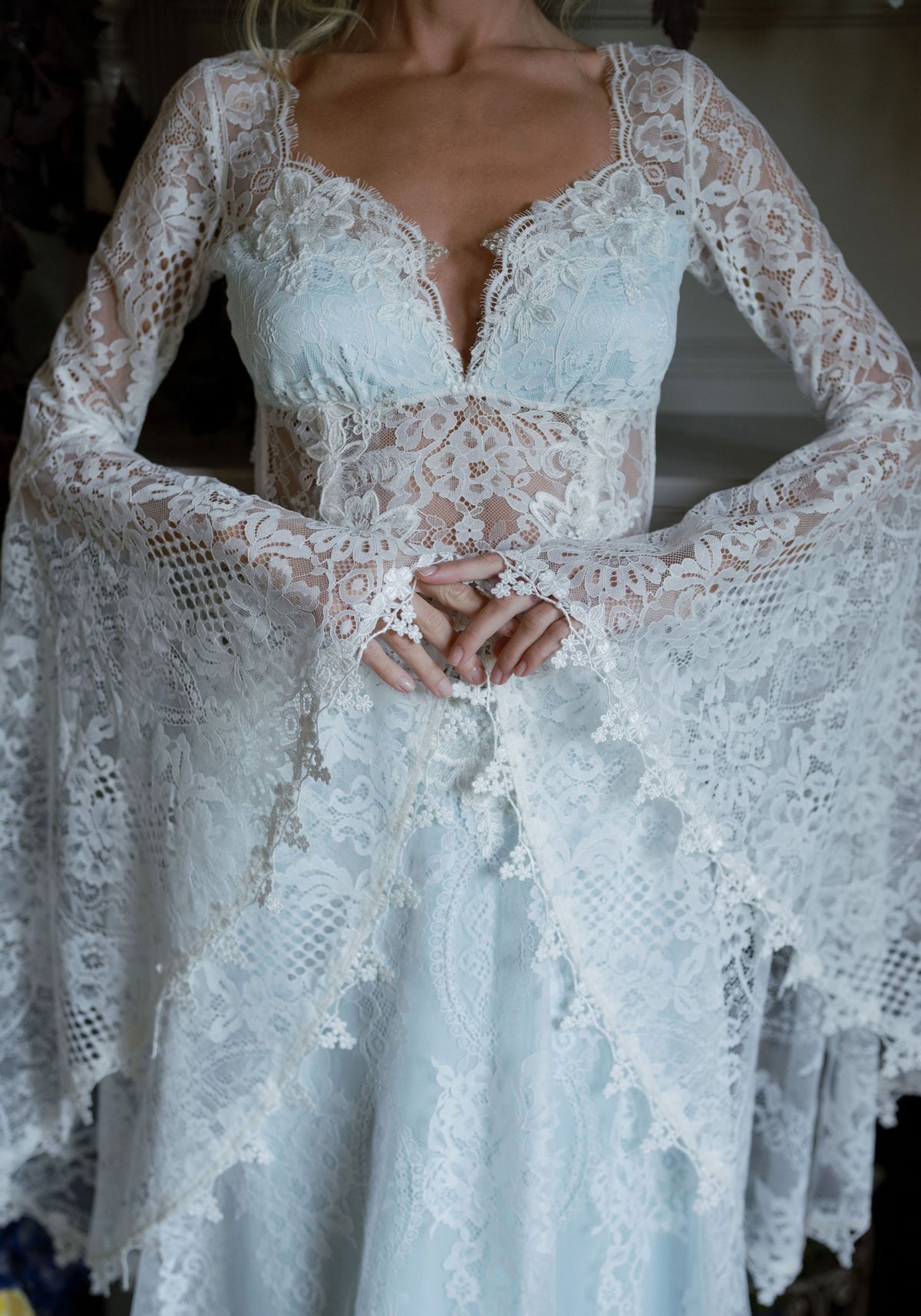 Detail of the Serenade scalloped lace sweetheart neckline, sheer waist and lace bell sleeves