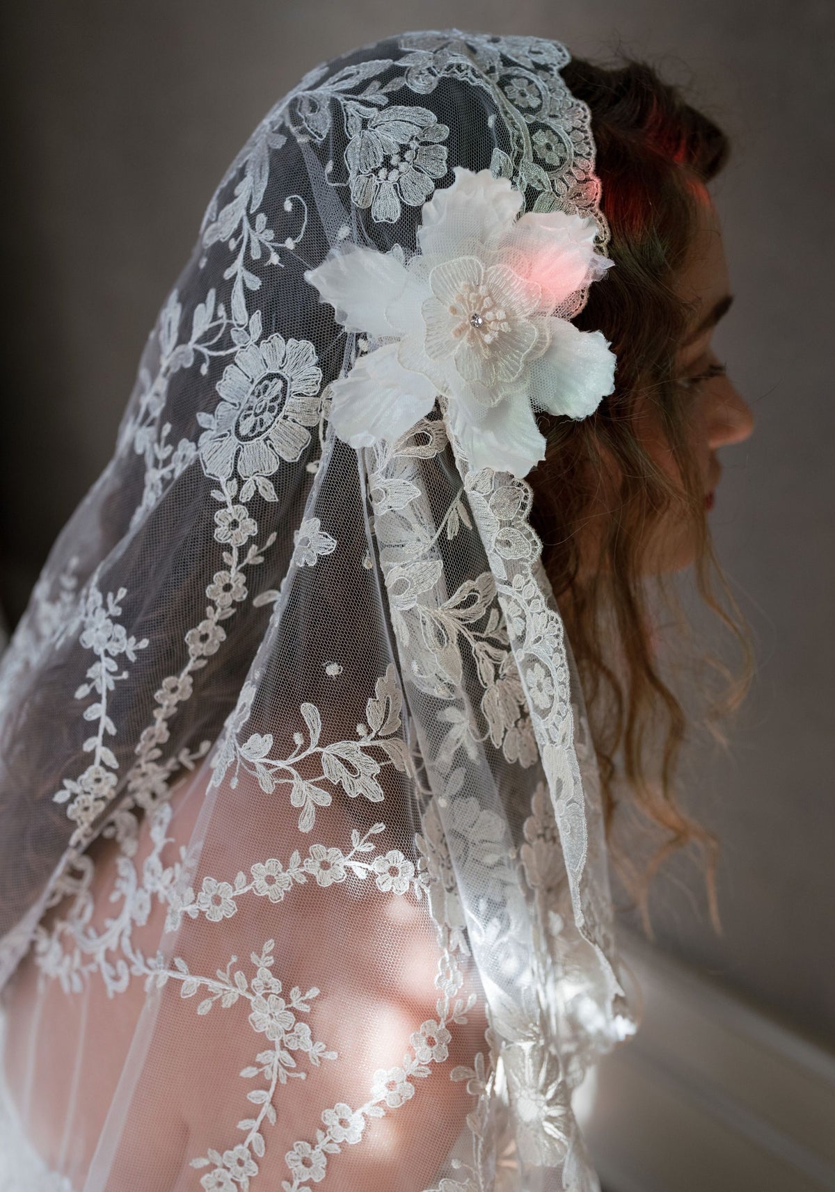 Close-up of the Sonnet veil with floral embroidered tulle and a dimensional silk flower