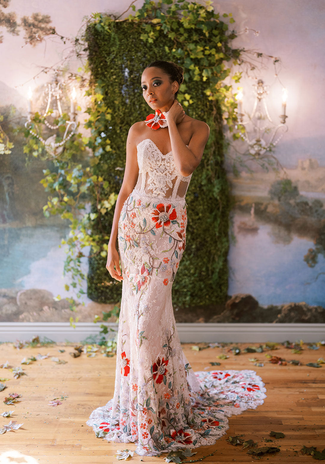 Bride in a luxe strapless lace gown with vibrant red and pastel floral embroidery.