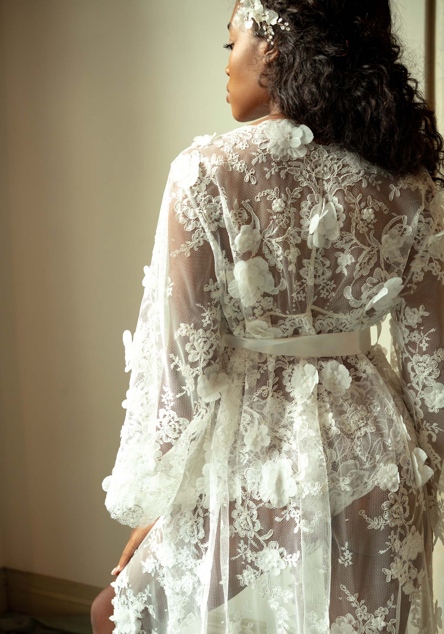 Floor-length white lace boudoir robe with intricate floral embroidery and sheer long sleeves.
