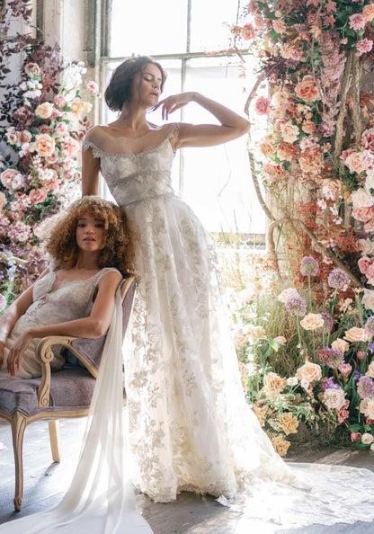 Two models wearing Claire Pettibone designs Vermeil Gold Wedding Dress